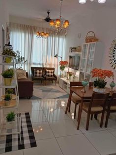 a living room filled with furniture and lots of plants on top of the table in front of a window