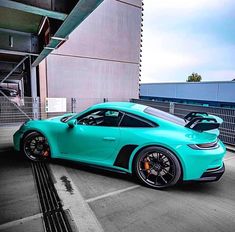 a blue sports car parked in front of a building