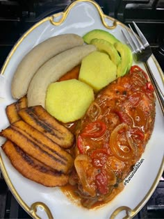 a white plate topped with meat, potatoes and veggies next to a fork