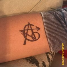 a person with a tattoo on their arm that has an anarchy symbol in the middle