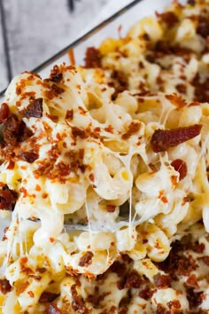 a close up of a pasta dish with bacon and cheese