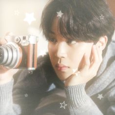 a person taking a photo with a camera and stars on the wall behind them,