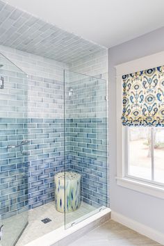 a blue and white bathroom with glass shower