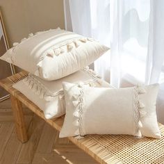 two white pillows sitting on top of a wooden bench