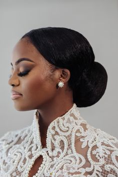 a woman with black hair wearing pearls and a white dress is looking off to the side