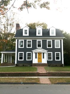 a black and white house with yellow door