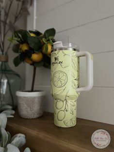 a cup that is sitting on top of a table next to some plants and a potted plant