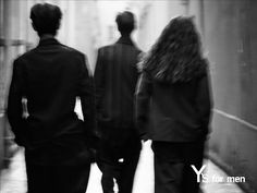 three people walking down an alley way