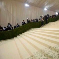 the stairs are lined with people in tuxedos