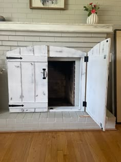 an old fireplace has been painted white and is being used as a storage unit for the fire place