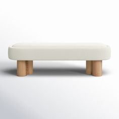 a white bench sitting on top of a white floor next to a wall in front of it