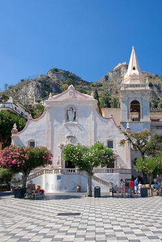 an old church with people walking around it