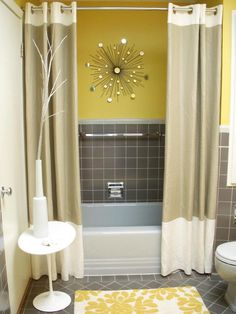 a bathroom with yellow and gray decor on the walls