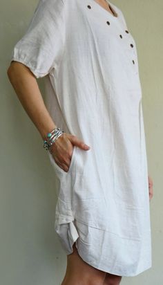 "A boho casual chic short sleeve cotton mix linen dress/tunic with curved hem. - Silhouette- - Loose fit body - Short sleeves - Pleated front dress - Curved hem - Hidden pockets in side seams of the dress - Body length - 94cm/37\" (longest part) Model is 161 cm. tall with the waist of 28\" and the hip of 38\" Status: ready to ship Weight: 302g Measurement: Tunic /dress (approximately) Shoulder: 16.25\" Bust: 42\" **can fit upto bust max38\" Armhole: 22\" Sleeve: 9\" Hip: 48\" **can fit upto bust Short Sleeve Relaxed Fit Tunic For Vacation, Vacation Tunic With Relaxed Fit And Short Sleeves, Relaxed Fit Short Sleeve Tunic For Vacation, Relaxed Short Sleeve Summer Dresses, Casual Short Sleeve Mini Dress For Vacation, Beige Short Sleeve Linen Dress For Vacation, Beige Short Sleeve Summer Dress, Short Sleeve Tunic For Vacation, Summer Tunic With Short Sleeves For Daywear