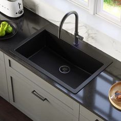 a black kitchen sink sitting on top of a counter