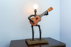 a wooden toy with a light on top of it and a guitar in the shape of a robot