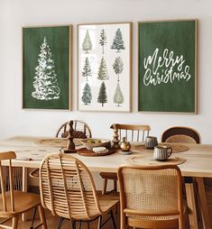 a dining room table with four chairs and three christmas trees on the wall above it