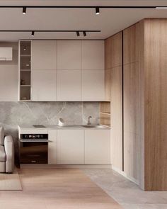 a living room and kitchen are shown in this modern style apartment with white walls, wood flooring and cabinets