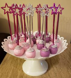 there is a cake with pink and purple frosting on it, surrounded by sparkle wands