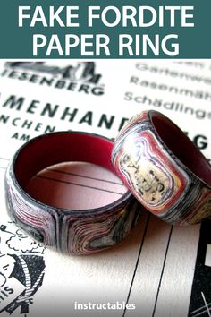 two wedding rings sitting on top of a piece of paper with the words fake fordite paper ring