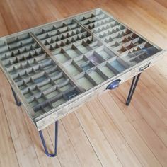 a table made out of glass blocks on top of a wooden floor with metal legs