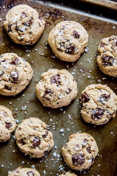 chocolate chip cookies on a baking sheet with sea salt sprinkled on top, ready to go into the oven