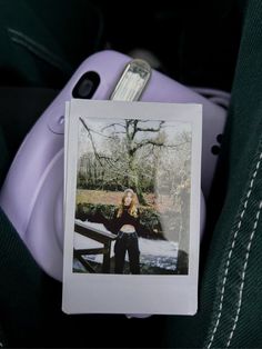 a polaroid photo sitting on top of a piece of luggage next to a purple suitcase