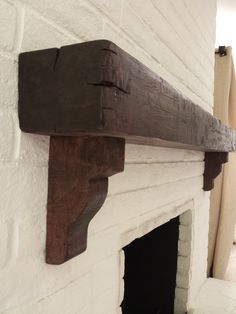 a white brick fireplace with a wooden shelf above it