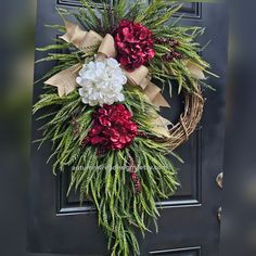 a wreath with red and white flowers is hanging on the front door to give it a festive feel