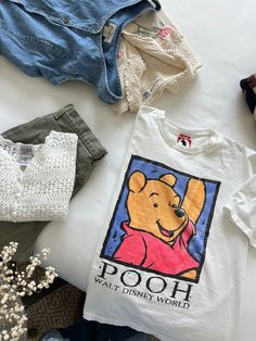 Fun vintage graphic Winnie the Pooh tee from the 90s with large graphics on the front. So sweet. Light wear on the graphics. In good vintage condition. Measurements taken while item is laid flat. Measurements: bust: 21" length: 24" Tag size: No tag size Fabric: No fabric details Model is 5'6 with a waist 26" and hips 36" FOLLOW US ON INSTAGRAM @theweathereddaisy FOR RELEASE DATES + STORY SALES! SHOP OUR WEBSITE theweathereddaisy.com FOR EVEN MORE EXCLUSIVE APPAREL. Disney Graphic Tees Vintage, Winnie Pooh T Shirt, 90s Graphic Tees Vintage, 90s Graphic Tees, Winnie The Pooh Vintage, Pooh Shirt, Surprise Az, Vintage Winnie The Pooh, Graphic Tees Vintage