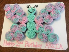 a butterfly shaped cupcake with pink and blue frosting