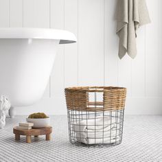 a white bath tub sitting next to a wooden stool