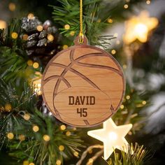 a wooden ornament with a basketball on it hanging from a christmas tree branch