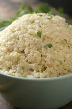 a bowl filled with rice sitting on top of a wooden table