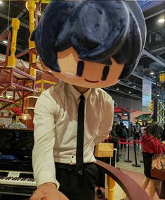 a man wearing a suit and tie standing next to a giant stuffed animal in front of a piano