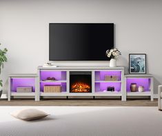 a living room with white furniture and a flat screen tv mounted above the fire place