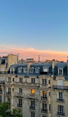 an old building with lots of windows and balconies on the top floor at sunset