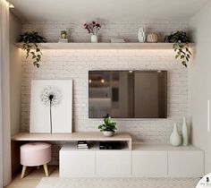 a living room with white brick walls and green plants on the shelves, along with an entertainment center