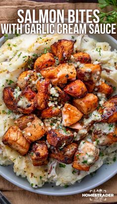 salmon bites with garlic cream sauce on top of mashed potatoes in a white bowl