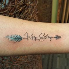 a woman's arm with an arrow and the words keep going tattooed on it