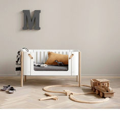 a baby's room with wooden toys on the floor and a letter m above it