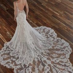 a woman in a wedding dress standing on a wooden floor with her back to the camera