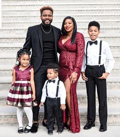 a man and two children standing next to each other in front of stairs with their parents