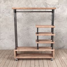 a wooden shelf on wheels in front of a concrete wall with black pipe and wood shelves