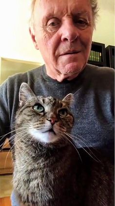 an older man holding a cat in his lap