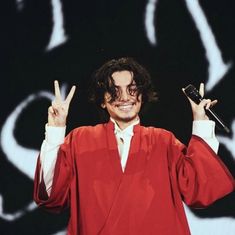 a man in a red robe holding up two fingers