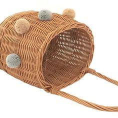 a wicker purse with pom - poms on it