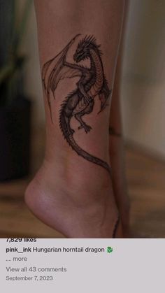 a tattoo on the leg of a woman's foot with a dragon drawn on it