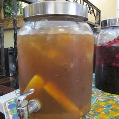 a glass jar filled with liquid sitting on top of a table next to a metal canister