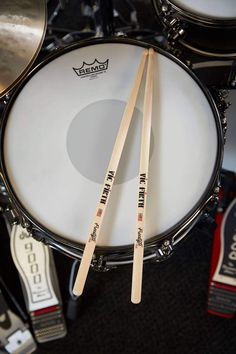 two drums are sitting on the floor next to each other with sticks sticking out of them